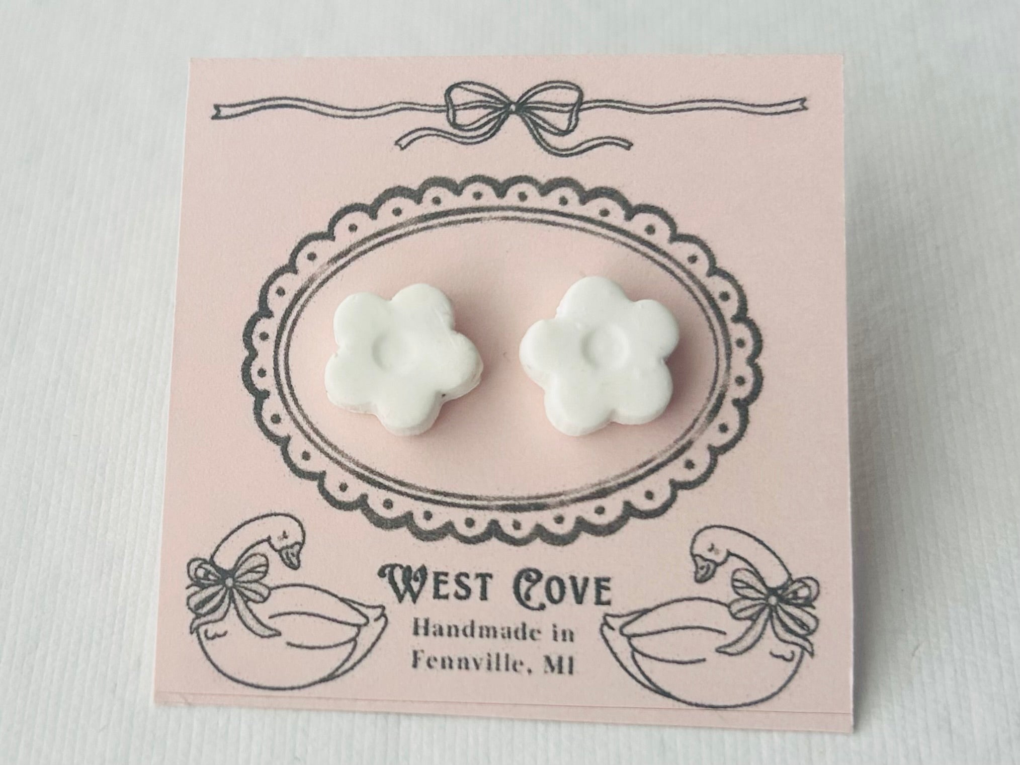 White daisy-shaped polymer clay earrings, 0.5 inch, hypoallergenic stainless steel backs, handmade in Fennville, MI.