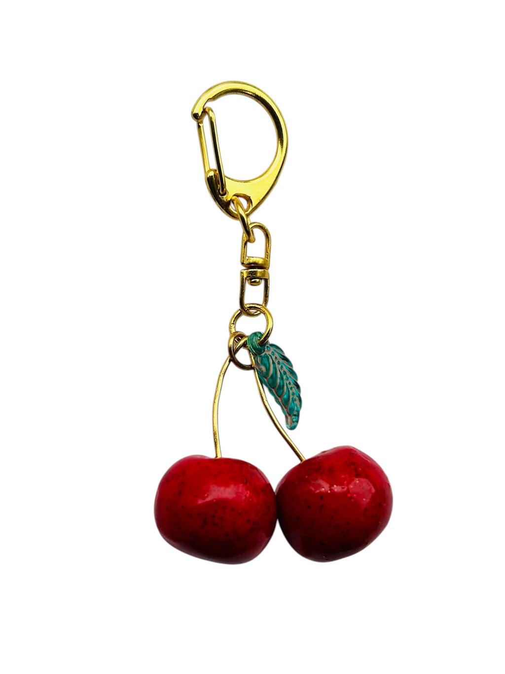 Cherry charm keychain for women with dual red polymer cherries, green leaf bead, and gold-plated clasp.