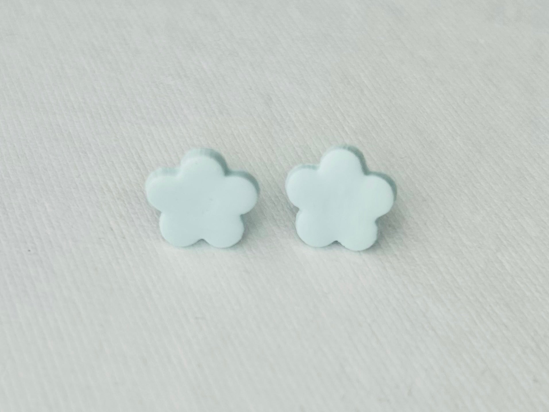Light blue daisy polymer clay earrings with stainless steel hypoallergenic backs, handmade in Fennville, MI.