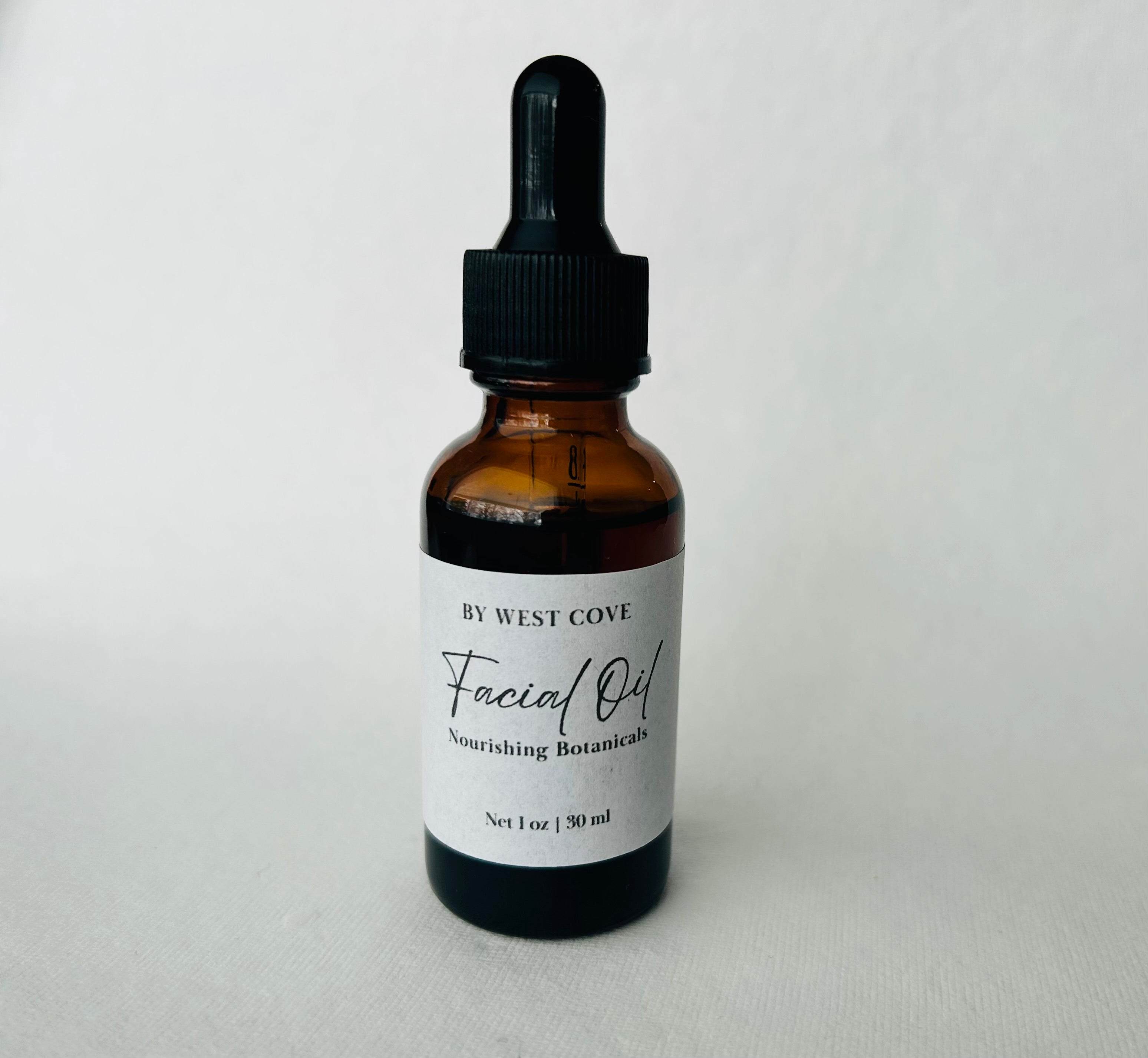 Facial oil bottle with dropper labeled 'By West Cove' on a white background