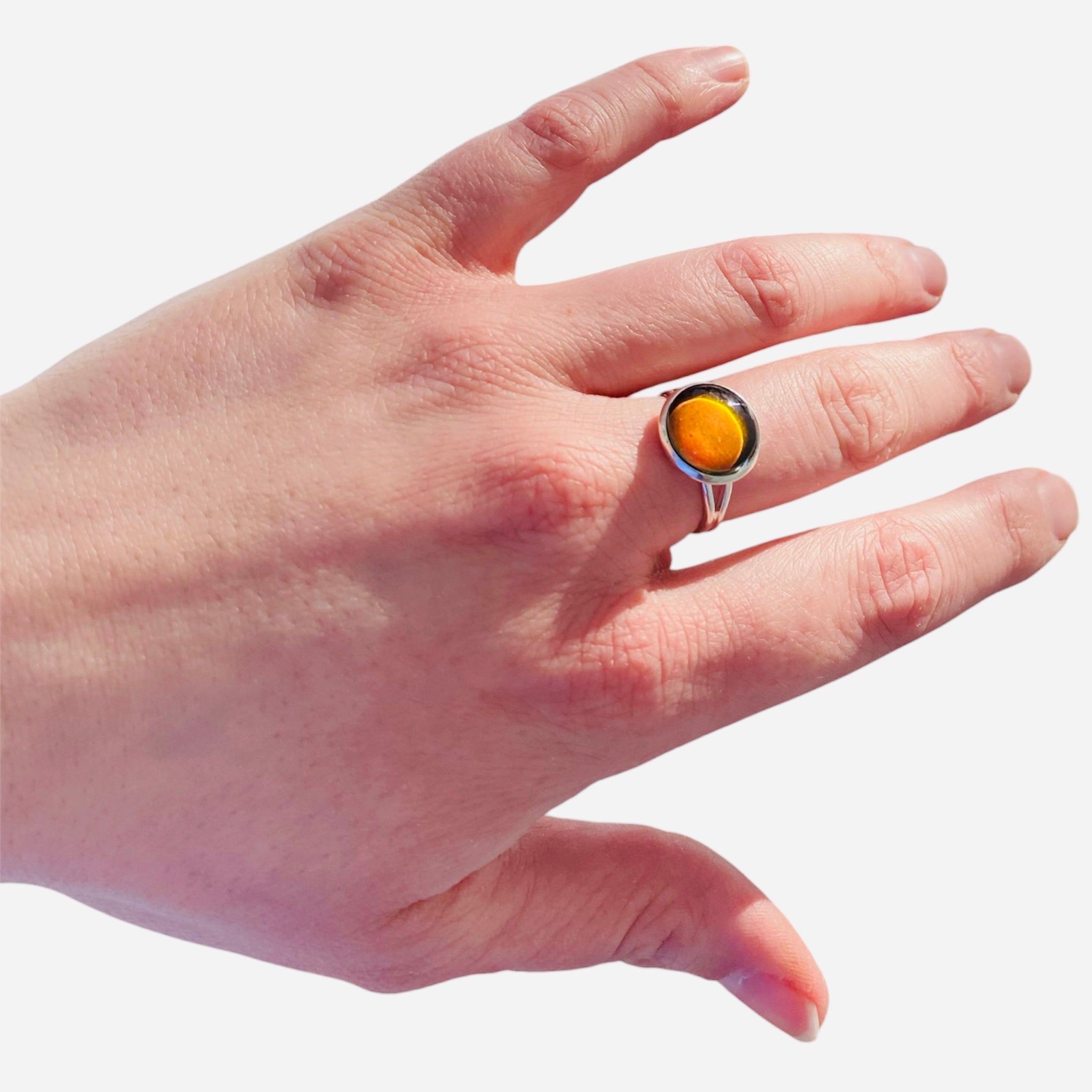 Mood Ring with orange amber gemstone on finger.