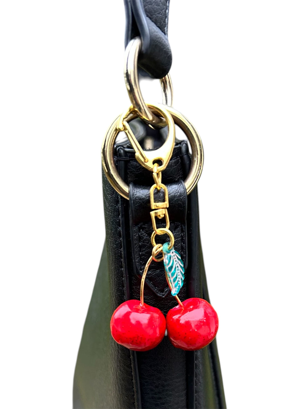 Cherry charm keychain for women red polymer cherries with epoxy glaze, green leaf bead, copper wire knot on gold clasp.