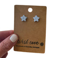 Light blue polymer clay starfish stud earrings on kraft display card, coastal beach jewelry.